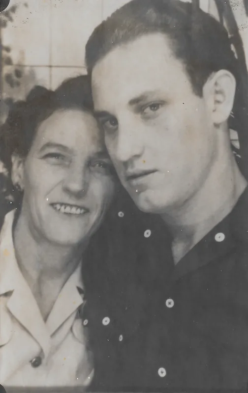 Black-and-white close-up of a young man and an older woman with their heads together